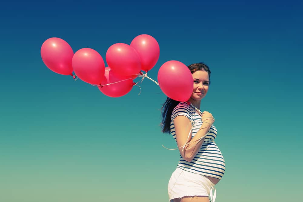 A pregnant woman's safe place hypnobirthing anchor which is balloons on a beach
