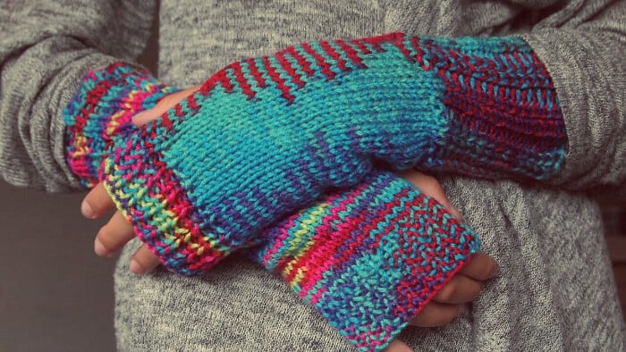 woollen gloved hands resting on top of each other to demonstrate the warming effect of glove anesthesia technique in hypnobirthing