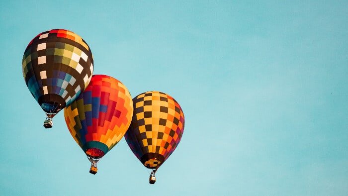 hypnobirthing-breathing-practice three multicoloured hot air balloons floating in a clear blue sky which are a hypnobirthing visualisation using hypnobirthing breathing